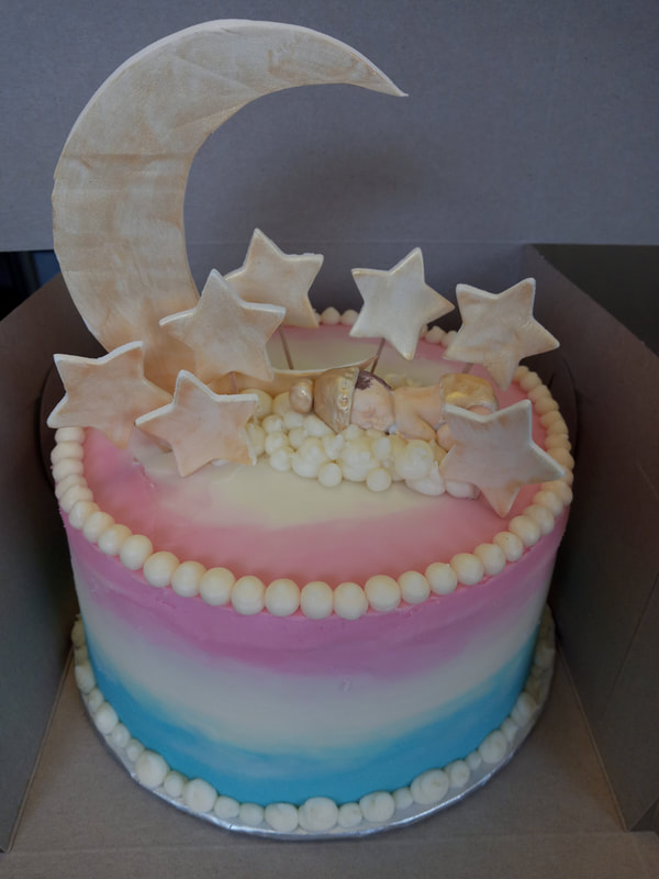 Blue white and pink cake with gold stars, moon and cloud with a baby sleeping on the cloud