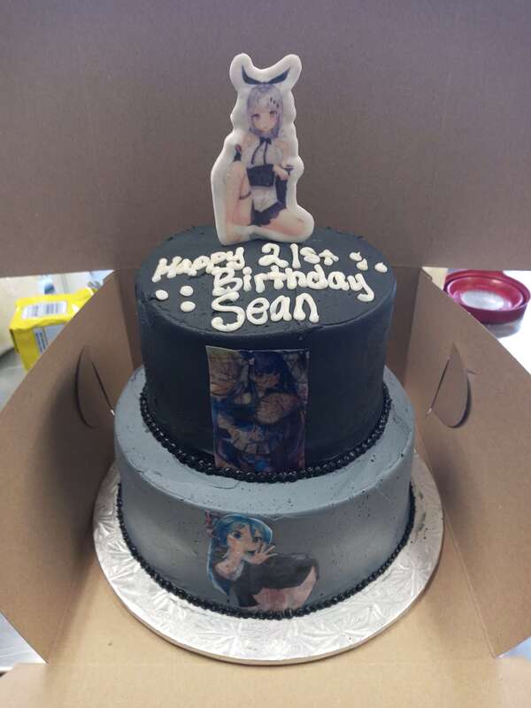 Two tiered cake with pictures of anime girls