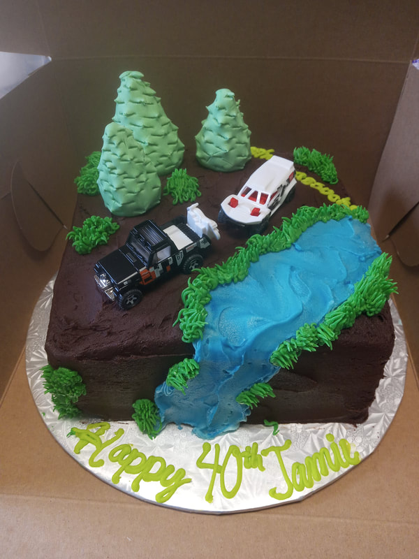 Cake with trees, a river, an off road vehicle and a tow truck