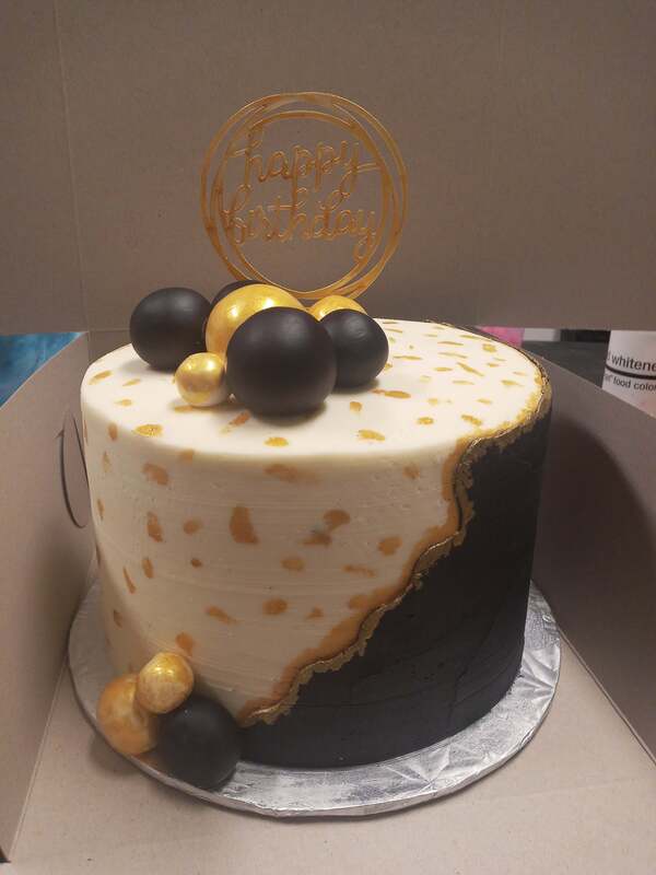 White cake with black and gold decorations