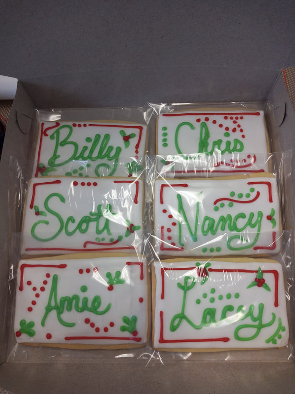 White cookies with green names and red decorations