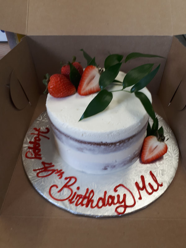 Lightly iced white cake with strawberries on top
