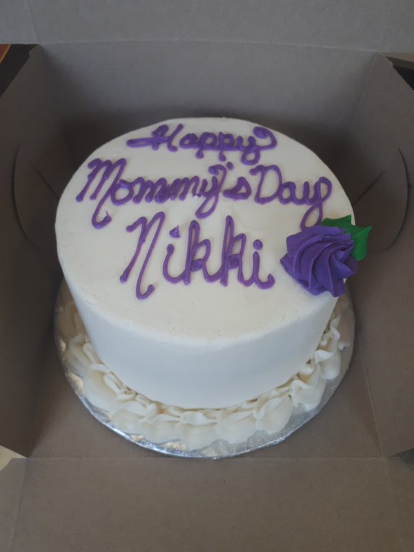 White mother's day cake with purple flower and writing