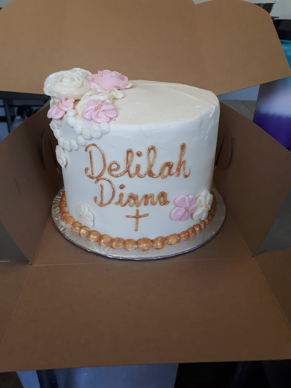 White communion cake with pink and white flowers and gold writing