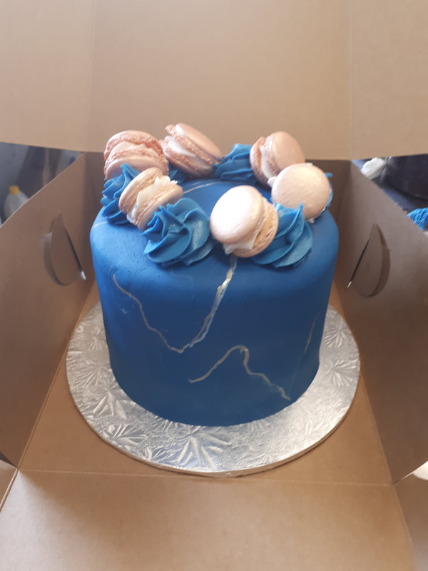 Blue cake with gold fissures and pink macarons