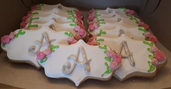 Pretty cookies with roses along the sides and a decorative 'A' in the middle