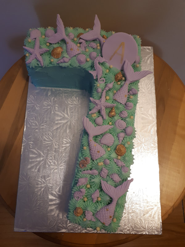 Under the sea cake with purple mermaid tails in the shape of a seven